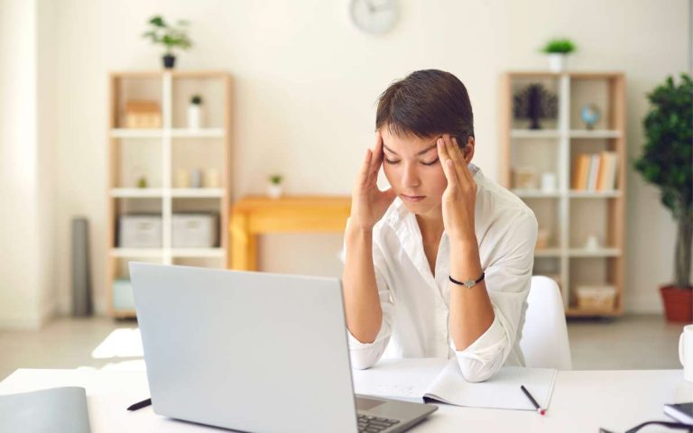 Una mujer con mucho estrés causado por la carga de trabajo
