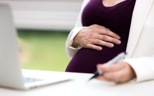 Una mujer embarazada solicitando su incapacidad por maternidad