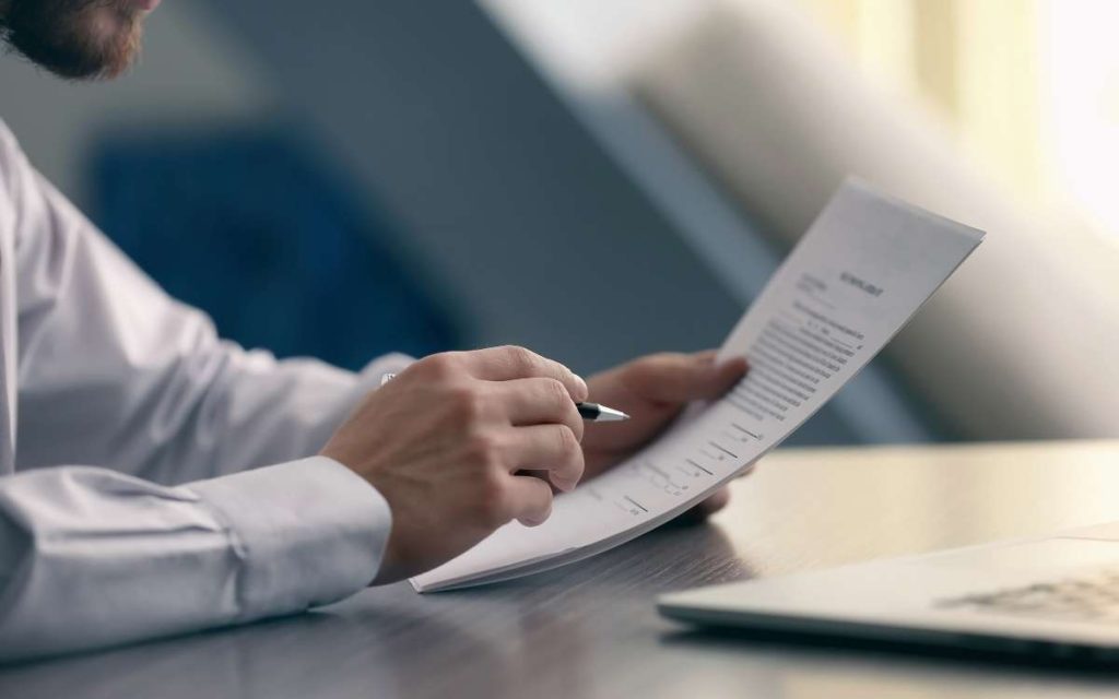 El director del area de recursos humanos leyendo un justificante laboral