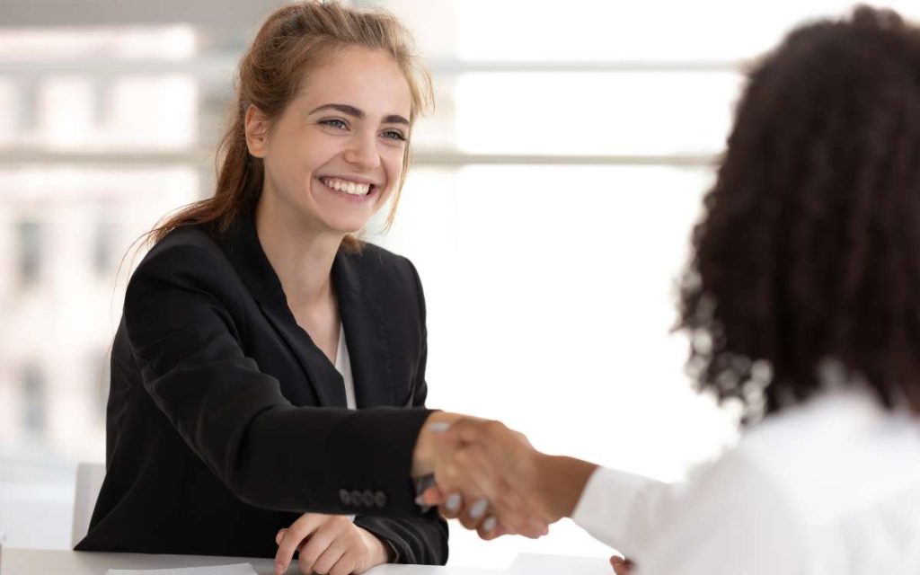 Una mujer de recursos humanos hablando con una empleada para mejorar la comunicación de percepciones y deducciones en la nómina