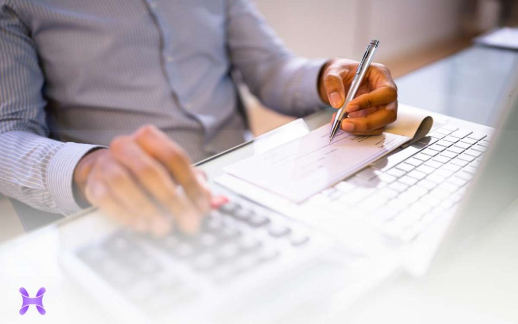 Un empleador haciendo un cheque para entregar el finiquito laboral a un empleado