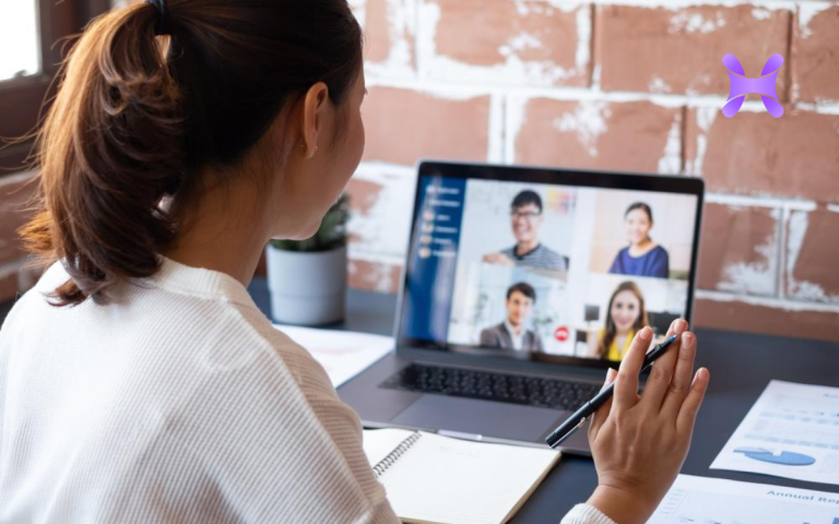 en la imagen se ve a una chica de espaldas trabajando en su computadora.