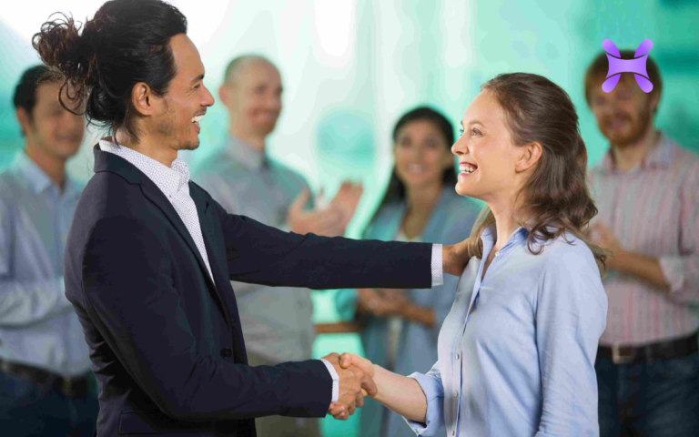 en la imagen se ve a un hombre felicitando a una mujer por su trabajo