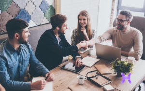 En la imagen se ve a un grupo de personas trabajando en una mesa